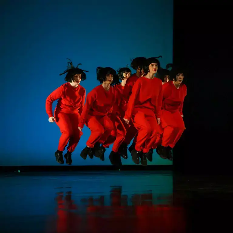 People in red outfits jumping at the same time